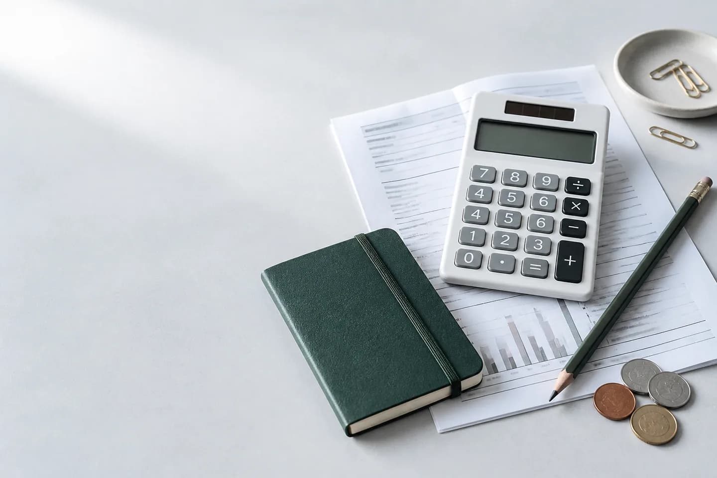 Calculator, notebook, and household budget papers on a desk